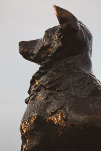 A vertical of a monument of a dog looking straight forward
