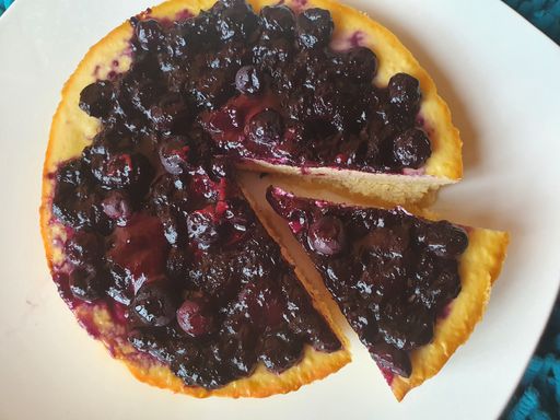 A closeup shot of tasty Blueberry pie with one sliced piece on a white plate