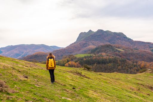 A young woman walking on top of Mount Erlaitz in autumn in the town of Irun