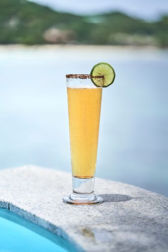 A vertical shot of a glass of beer with a piece of lime