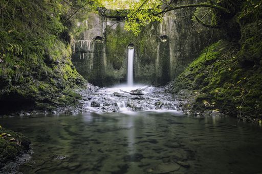 A horizontal view of a small waterfall in the forest