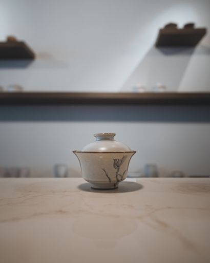 A vertical shot of a teacup on a marble tabletop in Silk tea house with a blurry background