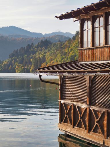 A vertical shot of a wooden building with a background of a lake