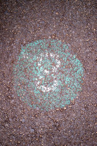 A vertical top view of white cleaned spray paint number 8 on the asphalt ground