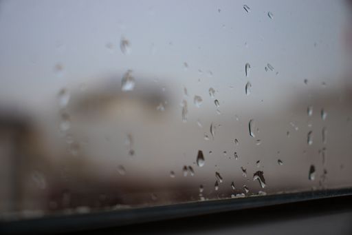 Beautiful moody shot, rain on a blurry window.