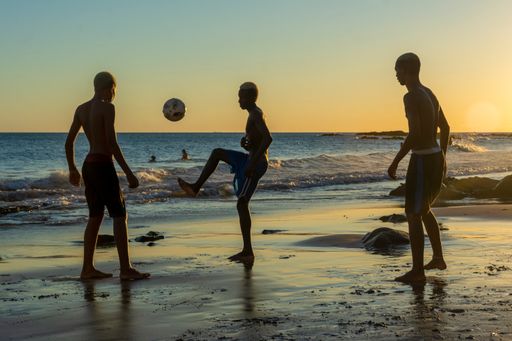 A group of Young people playing sand football at sunset on Ondina beach in Salvador, Bahia, Brazil