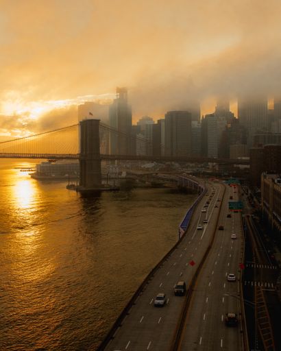 A scenic aerial shot of New York City during the sunset with the cityscape and the bridge showing