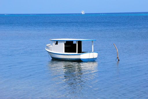 A beautiful shot of a small white boat on the blue calm sea on a sunny day