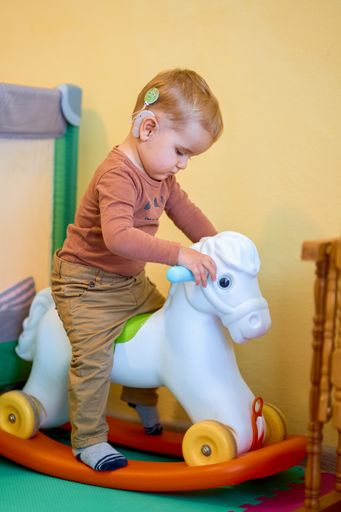 A shot of a deaf baby playing