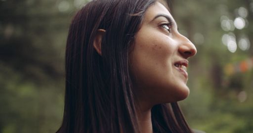 A side profile of a young beautiful Indian girl posing in nature