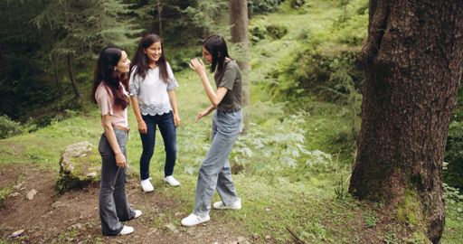 A group of young female South Asian friends laughing in a forest in India