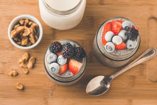 An overhead closeup shot of mixed berries in a jar with ice cream and greek nuts on the side