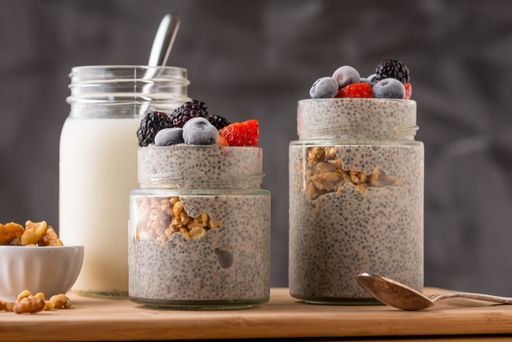 An overhead closeup shot of mixed berries in a jar with ice cream and greek nuts