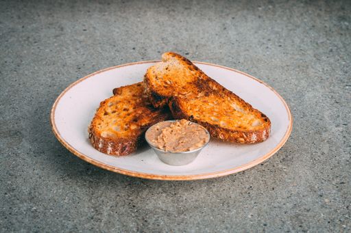 A closeup shot of toast slices with brown peanut butter dip on a plate