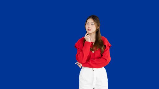 A closeup of a girl thinking on a blue background