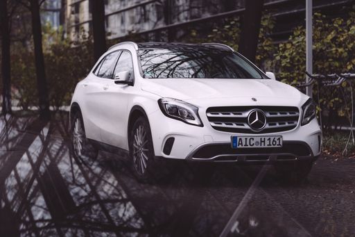 A Mercedes Benz A-Class parked in Munich, Germany in the autumn next to an office building