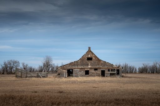 An old abandoned barn in the field under a gloomy sky in AlbertaCanada