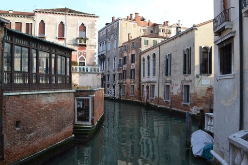 A beautiful shot of water in the middle of buildings under a blue sky
