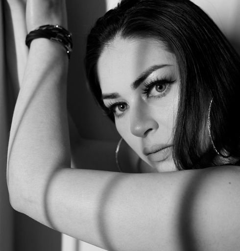 The grayscale closeup glamour woman's face with light coming from the window