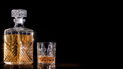 Whisky decanter and glass of whisky on blackground