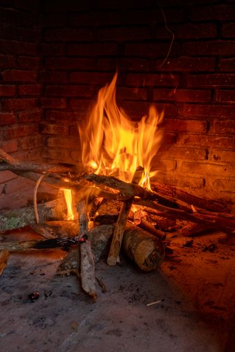 A vertical shot of burning wood in the fireplace