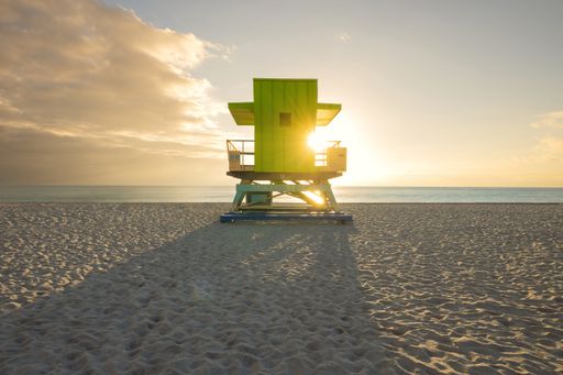 A green lifeguard tower on the beach during sunset in South Pointe Park, Miami, Florida