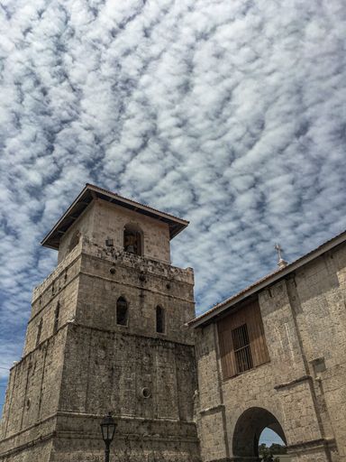 A low angle shot of the Baclayon Church in the Philippines and a cloudy sky