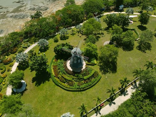 The aerial view of the windmill in the green garden. Hug Village, Don Sak District, Surat Thani Province, Thailand.