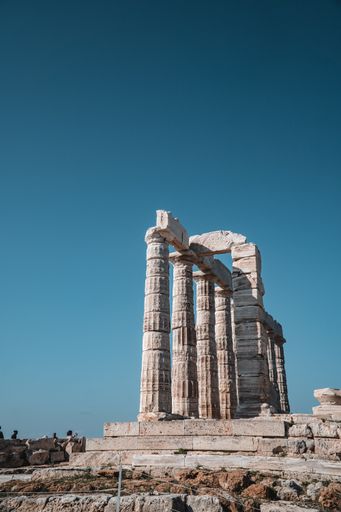 A vertical shot of columns of the Temple of Poseidon Laurium in Greece under the clear skies