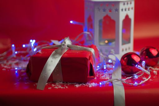 Red Christmas decorations next to a gift