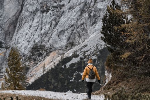 A beautiful view of a female hiker walking on the path under a magnificent mountain in Croatia