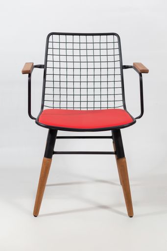 A vertical shot of a chair with a net on a chair's back behind a white surface