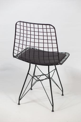 A vertical shot of a futuristic chair with a chain in the back behind a white background