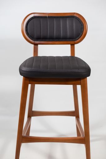 A wooden chair with a black leather seat isolated on a white background