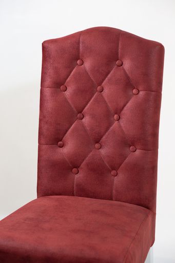 A vertical shot of a red chair with buttons behind a white background