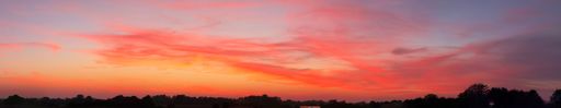 A panoramic shot of a breathtaking colorful cloudy sky at sunset