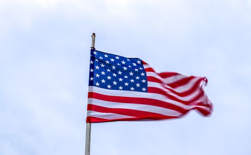 A low angle shot of a wavy flag under the cloudy sky