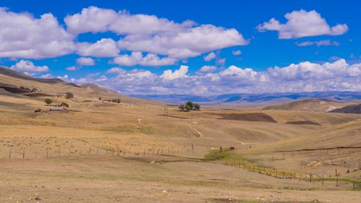 A beautiful shot of a landscape with hills, fields and blue sky