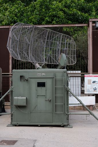 A vertical shot of a military mobile radar antenna group in the street.
