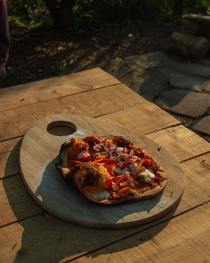 A high angle shot of a pizza on a wooden deck