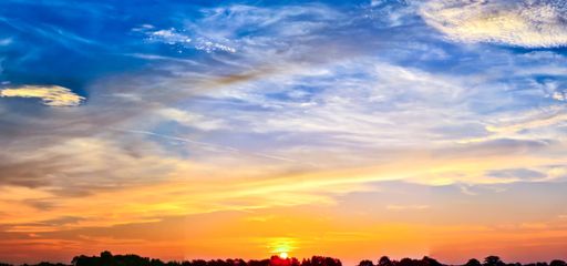 A panoramic shot of a breathtaking colorful cloudy sky at sunset