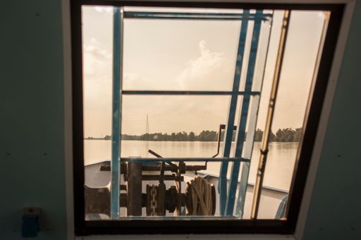 View of the river from the ferry window while sailing on the river itself.