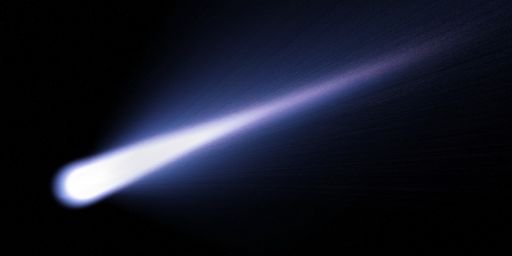 A white comet trail in the black night sky