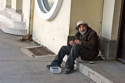 A beggar who spends time on the street waiting for someone to give him some money