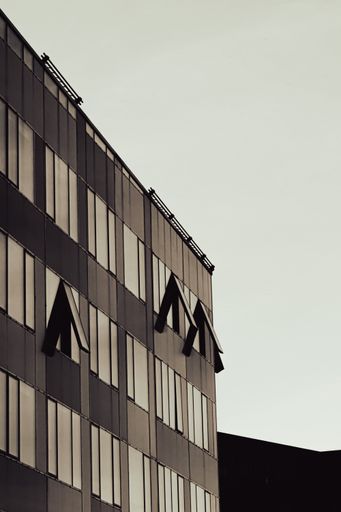 A vertical shot of a modern building on a street during the day