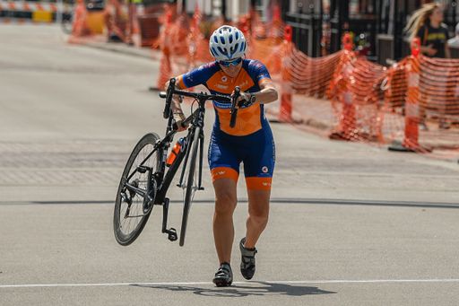 A closeup of a cyclist holding his bicycle while walking on the track at the inaugural Lebanon Criterium bicycle races in Lebanon Ohio , United States