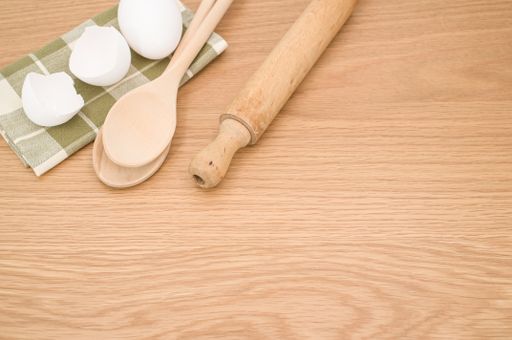 natural wood kitchen utensils and a table napkin on a wooden background with copy space