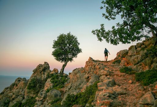 A rear view of a backpacker climbing a mountain in Crete, Greece