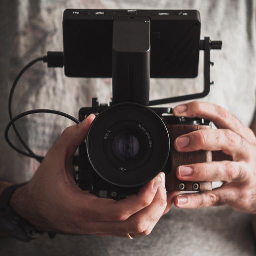 A vertical shot of a photographer taking a photo with a black camera
