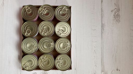 A top view of metal food cans placed on a wooden texture